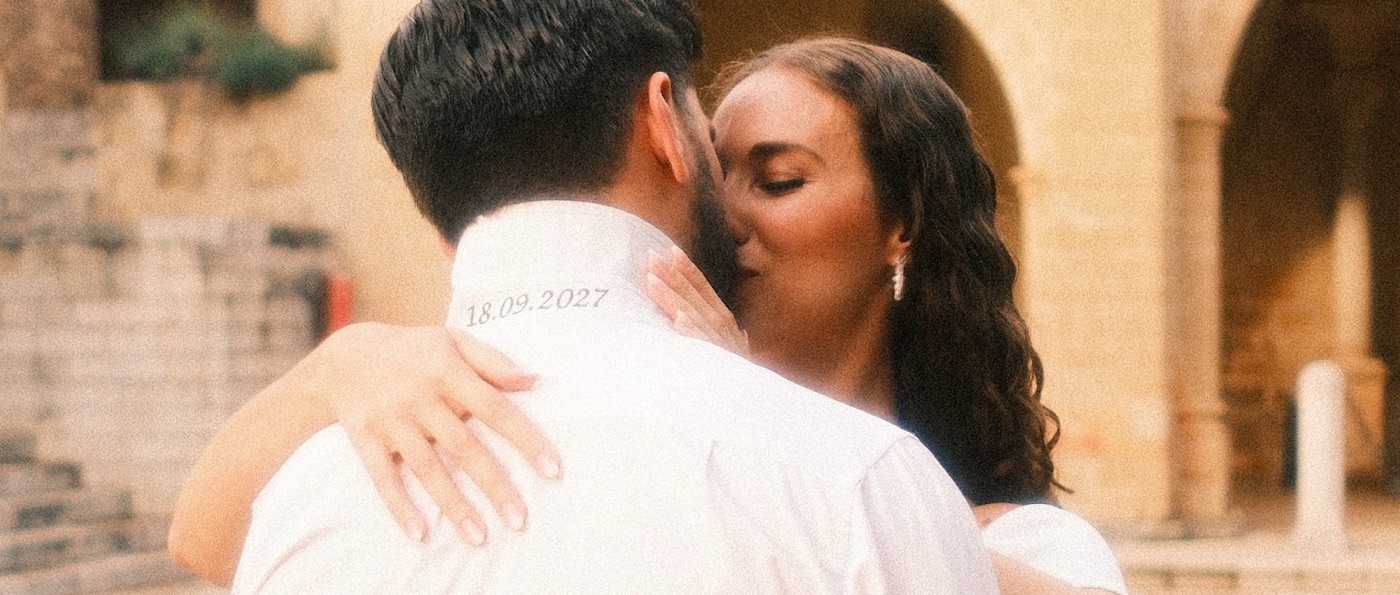 Raquel y Samuel abrazados, con la fecha de la boda bordada en la camisa