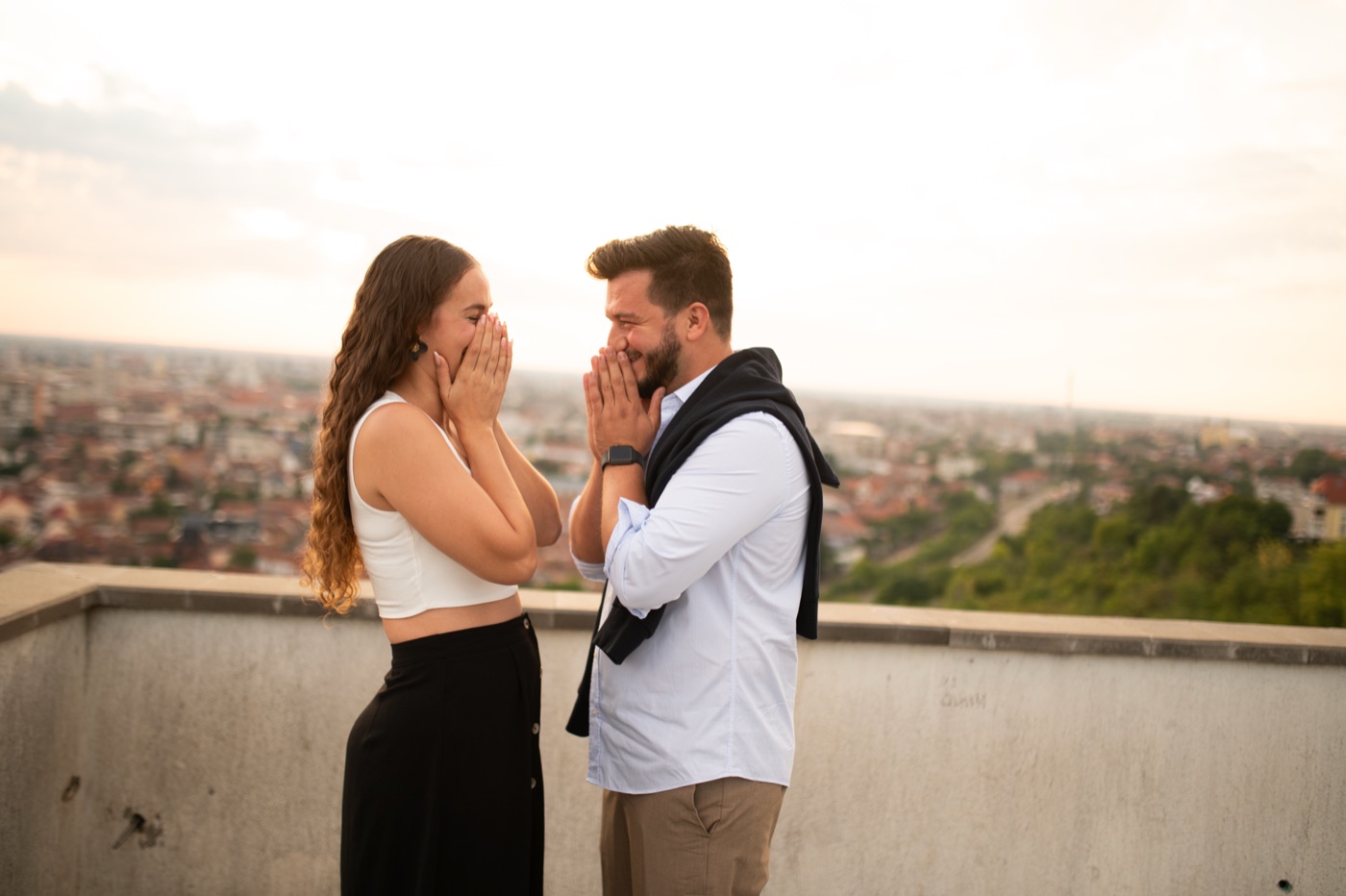 Raquel se tapa la cara emocionada frente a Samuel en un mirador sobre Oradea